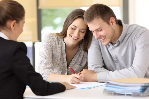 young couple signing documents